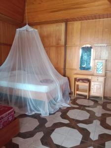 KododaLestari Cottages的一间卧室配有一张带蚊帐的床