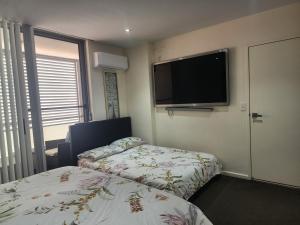 悉尼Parramatta Shared Apartment的酒店客房设有两张床和一台平面电视。