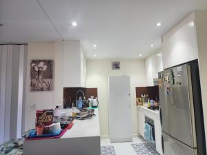 悉尼Parramatta Shared Apartment的厨房配有冰箱和台面