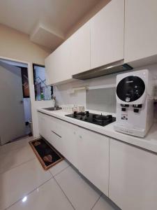 莎阿南Hijauan Homestay Shah Alam的厨房配有白色橱柜和炉灶烤箱。