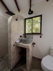 乌维塔拉维塔佩蒂达山林小屋的一间带石制水槽和窗户的浴室