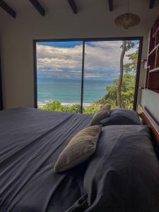 乌维塔拉维塔佩蒂达山林小屋的一间卧室设有一张床,享有海景