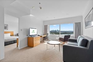 悉尼Holiday Inn Sydney Potts Point的酒店客房配有一张床、一张沙发和一张书桌。