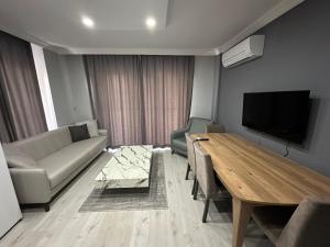 安塔利亚Tas Suites的带沙发、桌子和电视的客厅
