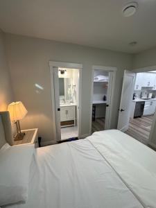 卡尔加里2 Bedroom 2 Washrooms Brand New Beautiful & Cozy Suite的卧室配有白色的床和带台灯的书桌