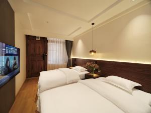 丽江丽江夕露小榭客栈的一间卧室配有2张白色的床和平面电视