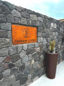 费拉Thimari Lodge的石墙上的一个标志,上面有盆栽植物
