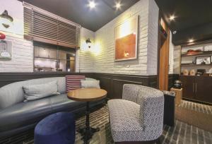 釜山Brown Dot Hotel Daeyeon的酒吧配有沙发、椅子和桌子