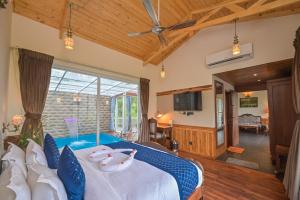 卡绍利Jungle Lodge Resort的一间卧室配有一张带蓝色枕头的大床