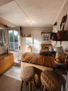 新普利茅斯The Secret Studio, Outdoor Bath & Pizza Oven的厨房配有木台和2张凳子