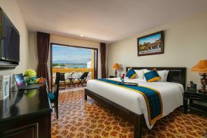 会安La Charm Hoi An Hotel & Spa的酒店客房设有一张大床和一个阳台。