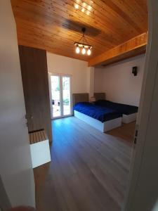佩尔梅特Bujtina Lugina e vjosës的一间卧室设有两张床和木制天花板