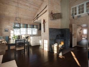 Saballie - Cosy cabin - sunny location!的厨房配有壁炉和桌椅。