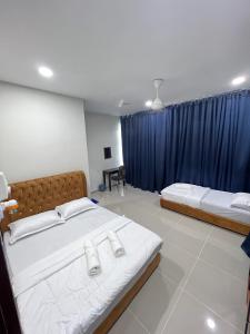 瓜拉丁加奴TAMU ROOMSTAY TOK MOLOR的一间卧室配有两张床和蓝色窗帘