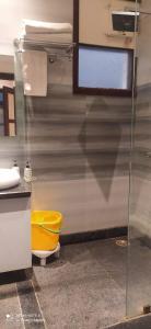 瓦拉纳西Hotel Atlantis的浴室设有黄色卫生间和玻璃墙