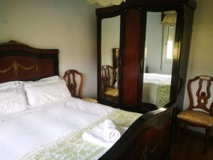 庞特维德拉Vixía do Val Classic的一间卧室配有一张带两把椅子和镜子的床