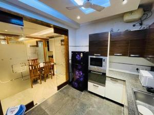 新德里Divine India Service Apartment 4Bhk D-163 Saket的厨房配有水槽和带微波炉的桌子