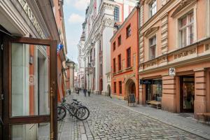 波兹南Sunny Apartments in the Heart of Poznań Old Town by Renters的一条在鹅卵石街道上停放自行车的街道