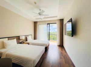 富国Vinholidays Fiesta Phu Quoc的酒店客房设有两张床和窗户。