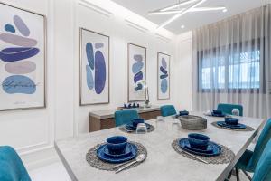 利雅德Mabaat - Al Qairawan - 30的一间带桌子和蓝色椅子的用餐室