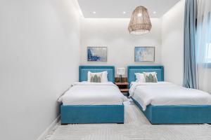 利雅德Mabaat - Al Qairawan - 30的一间卧室配有两张床和吊灯。