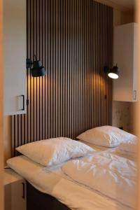 马尔克洛Zicht op Twente - Spa lodges的卧室内的两张床,配有白色床单和枕头