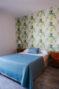 两姐妹蒙诺酒店的一间卧室配有一张带花卉壁纸的床