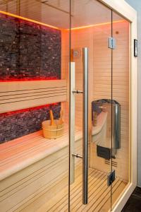 马尔克洛Mooi Twente Lodges - privé Spa en sauna的一间铺有木地板并配有玻璃门的桑拿浴室