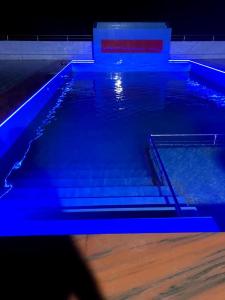 杰索尔Hotel Orion International的一座大型游泳池,上面有蓝色的灯光