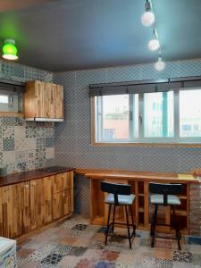 木浦市Deluna House的厨房配有木制橱柜和2张凳子