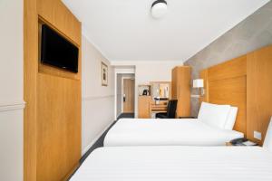 泰恩河畔纽卡斯尔凯恩客房酒店的酒店客房设有两张床和电视。