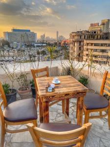 开罗Rotana Palace Suites的观景阳台配有一张木桌和椅子。
