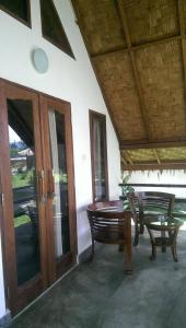 武吉拉旺Villa Paradise的门廊配有桌子、长凳和桌子