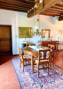SavignoCasa Stella Country House的一间位于地毯上的带桌椅的用餐室