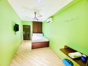 库马西Abanaba lodge& Restaurant的一间拥有绿色墙壁的卧室,其中配有一张床