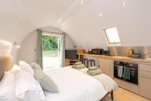 RamsdenThe Plough Inn Cabins的一间带一张白色大床的卧室,位于厨房