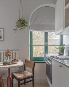 伦敦Mason & Fifth, Bermondsey的厨房配有桌子、椅子和窗户