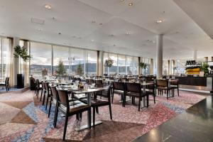 特隆赫姆Clarion Hotel Trondheim的餐厅设有桌椅和大窗户。