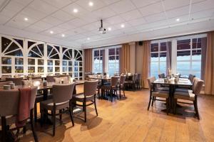 阿伦达尔迪霍尔蒙克拉丽奥酒店的用餐室设有桌椅和窗户。