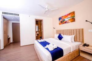 海得拉巴Casa Hotel & Suites, Gachibowli, Hyderabad的一间卧室配有一张大床和毛巾