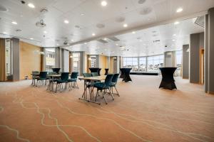 阿伦达尔迪霍尔蒙克拉丽奥酒店的一间铺有地毯并配有桌椅的会议室