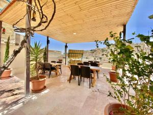 安曼Villa Mira Guesthouse - Downtown Central Amman - AL DIYRIH的一个带桌椅和一些植物的庭院