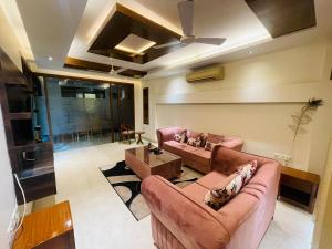 新德里Divine India Service Apartment 4Bhk D-163 Saket的客厅配有两张沙发和吊扇