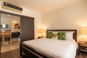 普拉卡海尔Roble Sabana 404 Luxury Apartment Adults Only - Reserva Conchal的一间带大床的卧室和一间厨房