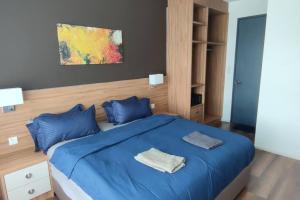 怡保H&W Sunway Onsen Suite Tambun Sunway City Ipoh的一间卧室配有蓝色的床和蓝色枕头