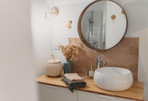 滨海吕克Grange Petite Brise bord de mer的浴室设有水槽和镜子,位于柜台上