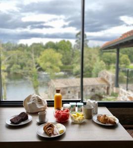 布拉加Casa do Engenho Braga的一张带早餐食品的桌子,享有窗户的景色