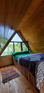 OniSeva Villa in Racha的木制客房的一张床位,设有窗户