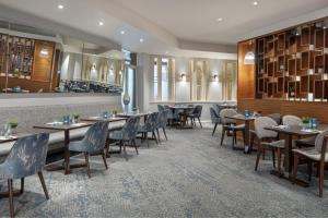 彼得伯勒Delta Hotels by Marriott Peterborough的一间带桌椅的餐厅和一间酒吧