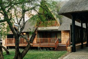 雾观Kruger Park Lodge Unit 531 - PMP的茅草屋顶房屋,带甲板